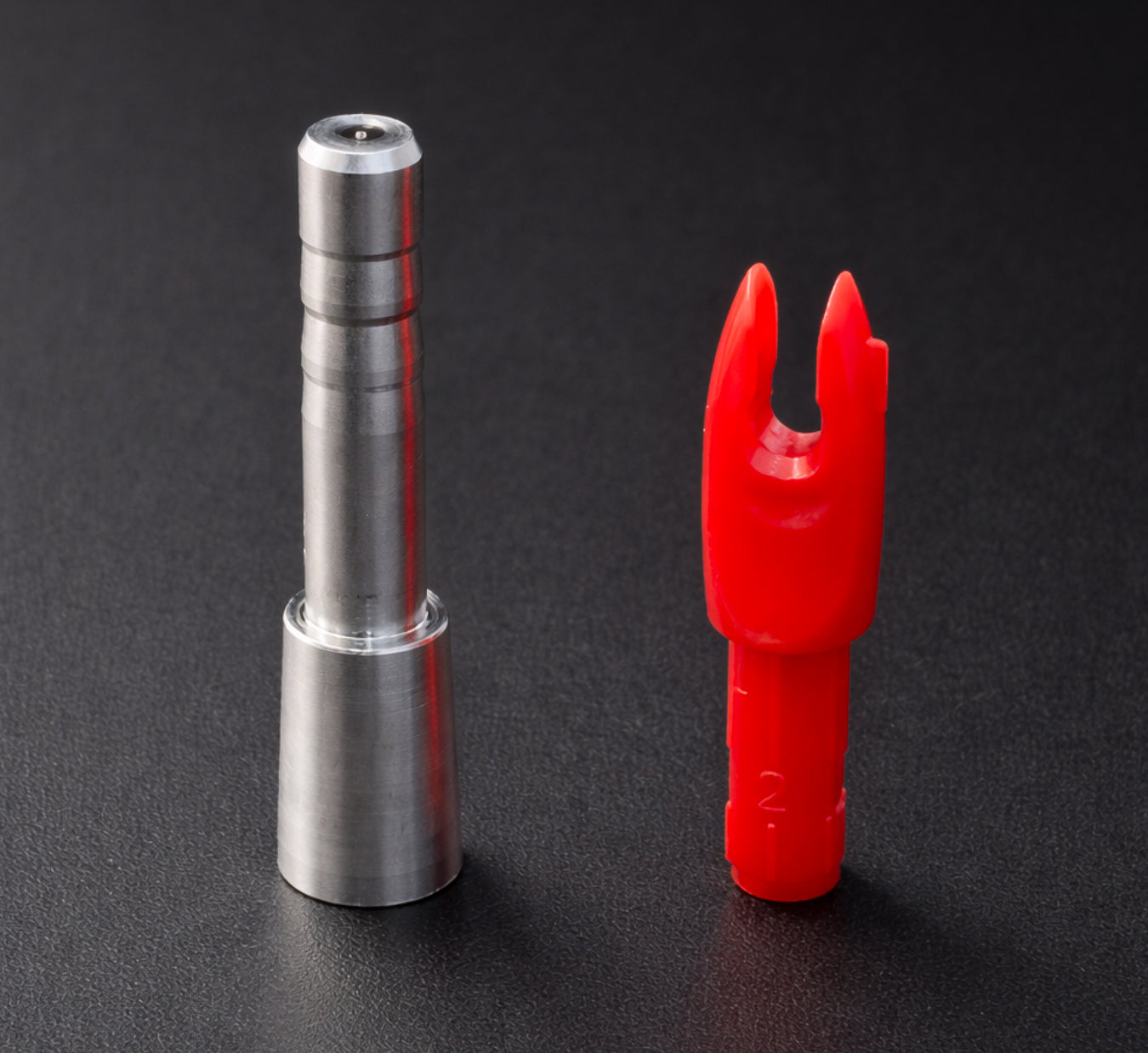 Metal and red plastic components on a black background