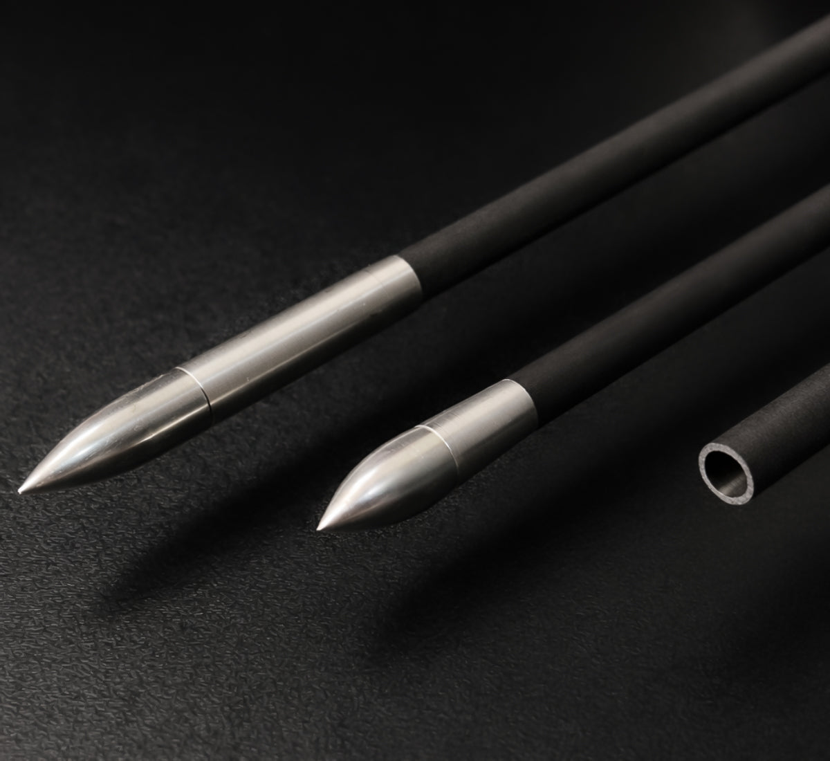 Three arrow shafts. Each with different ends on black background