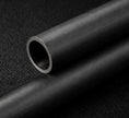Close-up of a black carbon tube on a textured black background
