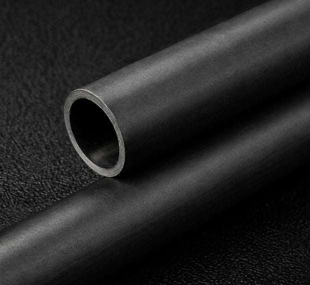 Close-up of a black carbon tube on a textured black background